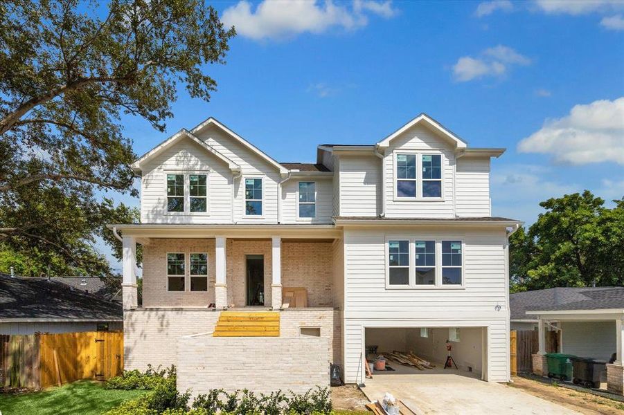 This new construction home is designed with a brick and Hardie siding combination, bringing both functionality and design interest. A brick accent wall serves as an architectural feature disguising the stairs to the front door, and providing a great space to hide packages. Photo as of 11/5/2024