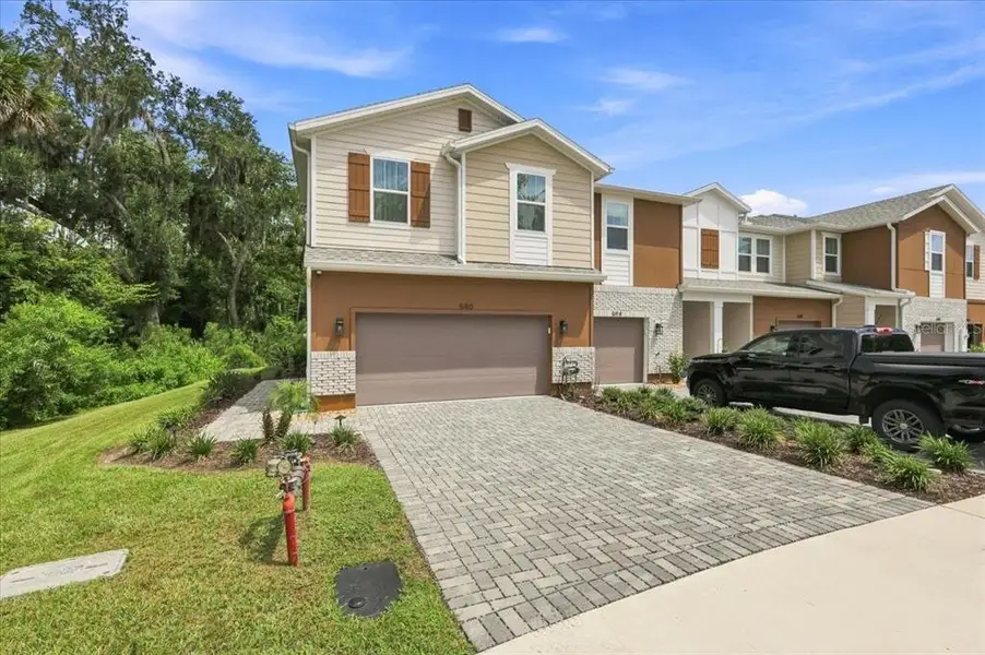 Front exterior of a new home in Towns at Riverwalk, Sanford, FL, highlighting curb appeal (Image 2). Front exterior of a new home in Towns at Riverwalk, Sanford, FL, highlighting curb appeal (Image 2).