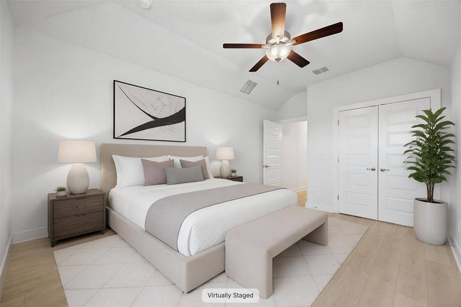 A well-appointed bedroom with light wood flooring offers a comfortable and serene retreat.