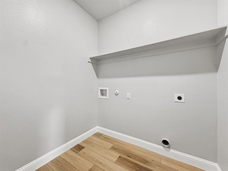 Laundry area with hookup for a gas dryer, hookup for an electric dryer, light wood-style floors, and hookup for a washing machine