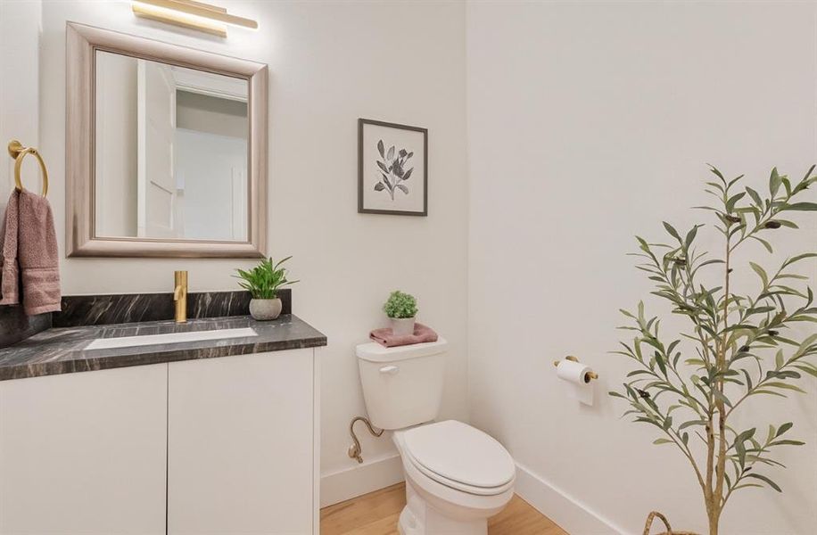 Half bath with vanity and wood finished floors