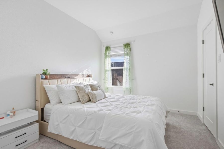 Bedroom with carpet and vaulted ceiling