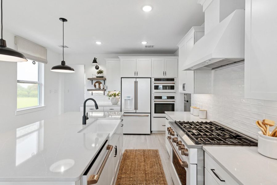 Stunning island kitchen with white cabinets and quartz counters (*Photo not of actual home and used for illustration purposes only.)