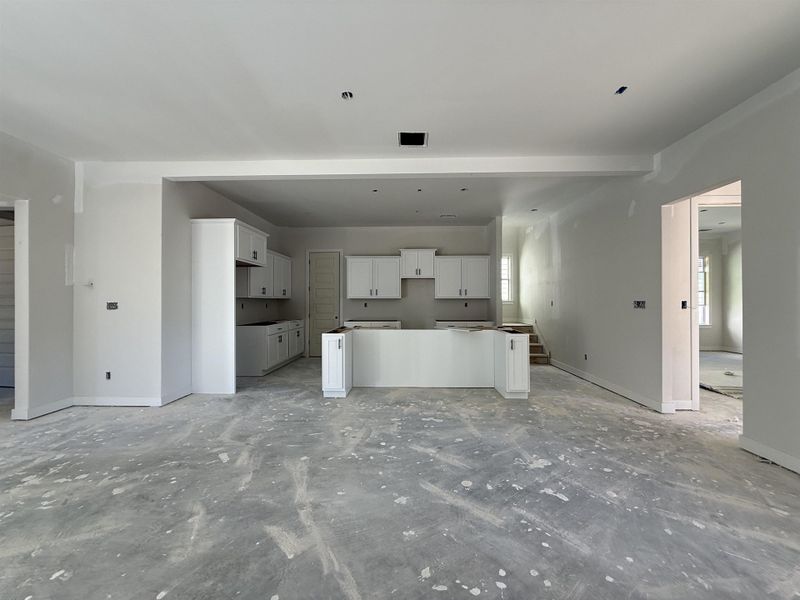 Unfurnished living room featuring baseboards and concrete floors