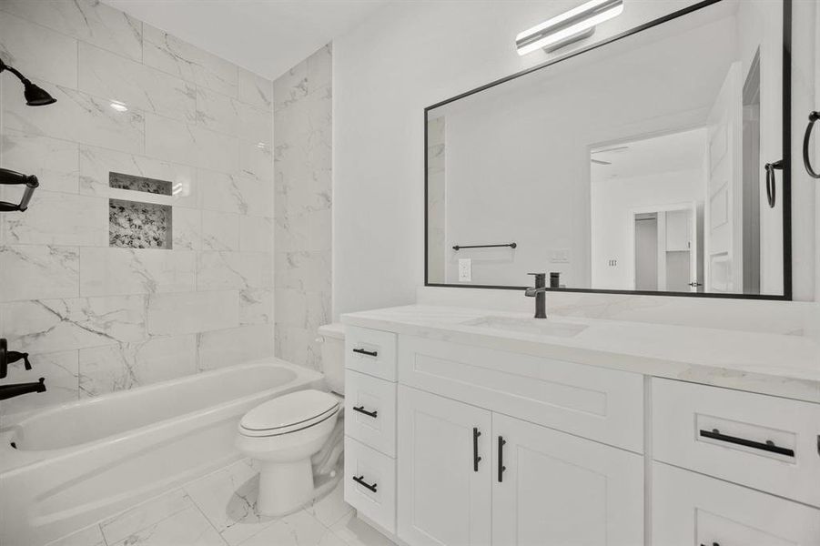 Second secondary ensuite bathroom featuring white cabinetry and high-end finishes.