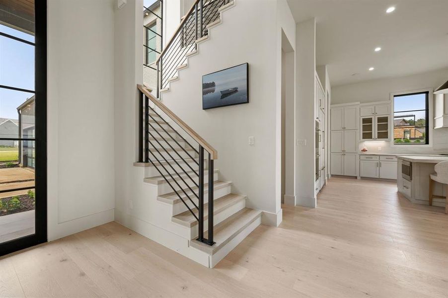 Stairway featuring wood finished floors, recessed lighting, and baseboards Stairway featuring wood finished floors, recessed lighting, and baseboards