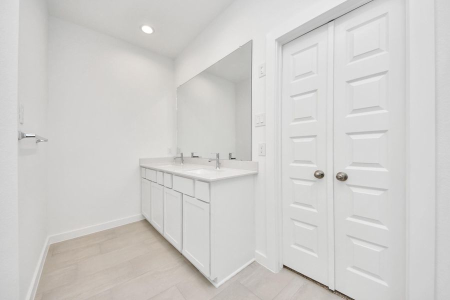 Elevate your daily routine at the elegant vanity, now equipped with double sinks, light countertops, modern hardware, and beautiful recessed lights. Sample photo of completed home with similar floor plan. Actual colors and selections may vary. Elevate your daily routine at the elegant vanity, now equipped with double sinks, light countertops, modern hardware, and beautiful recessed lights. Sample photo of completed home with similar floor plan. Actual colors and selections may vary.