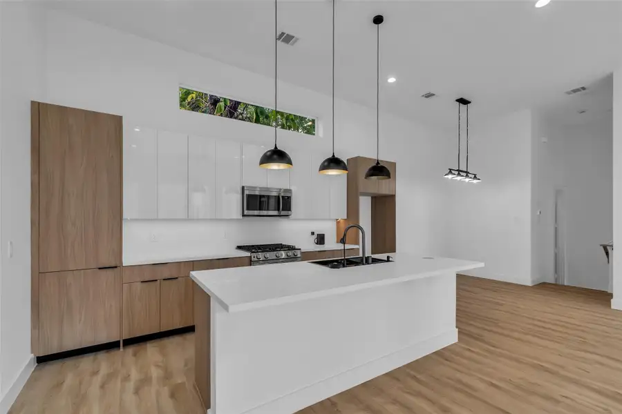 The kitchen includes a central island with a sink that also serves as a convenient breakfast bar, providing extra space for dining and meal preparation. The kitchen includes a central island with a sink that also serves as a convenient breakfast bar, providing extra space for dining and meal preparation.