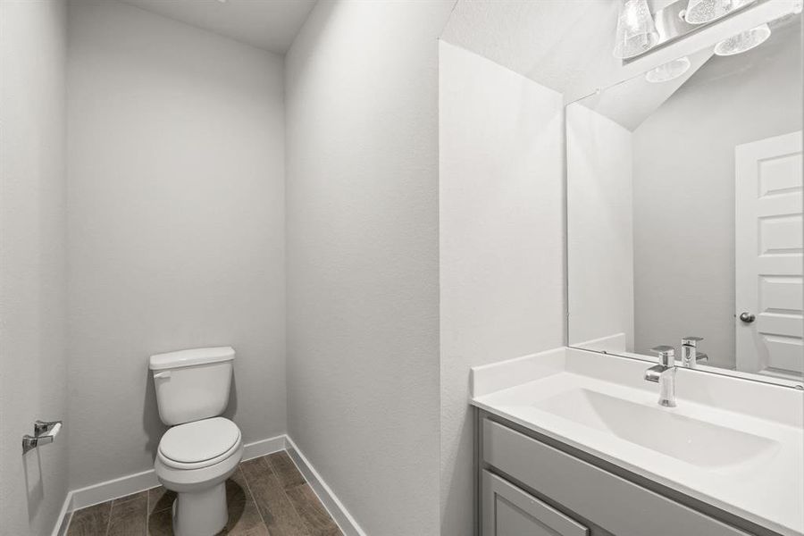 Step into this bright and airy half bath, where a sleek vanity, light counter tops,  and modern hardware elevate the space with contemporary charm. Sample photo of completed home with similar floor plan. As-built interior colors and selections may vary.