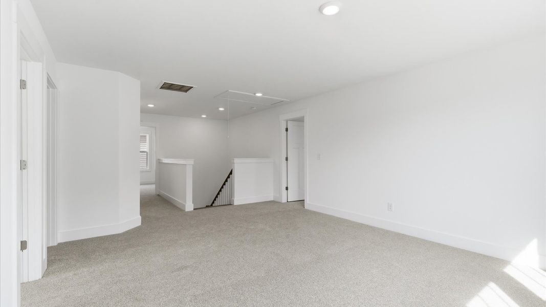 Highly functional loft featuring cozy carpet and open views of the home’s living areas at the Foxbank community