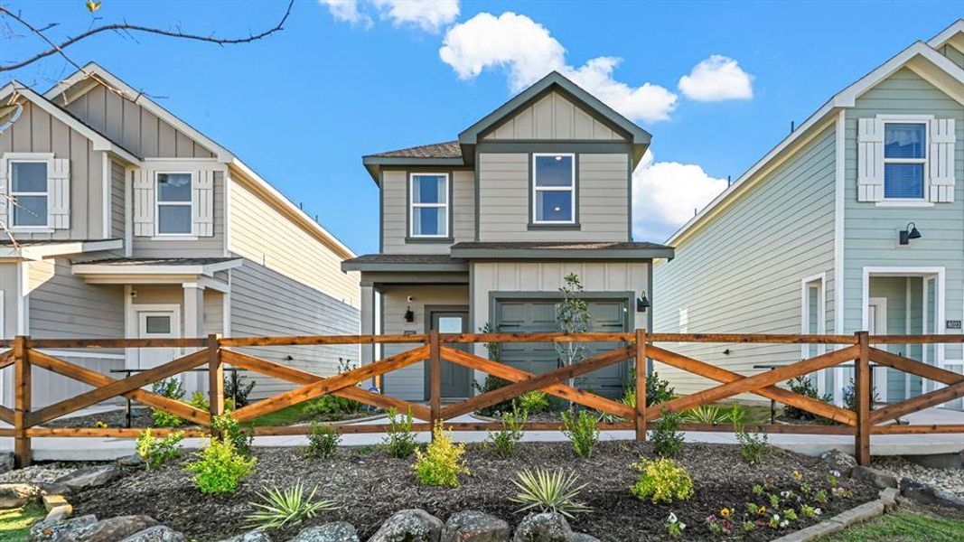 View of front of property with board and batten siding, a shingled roof, and a gate