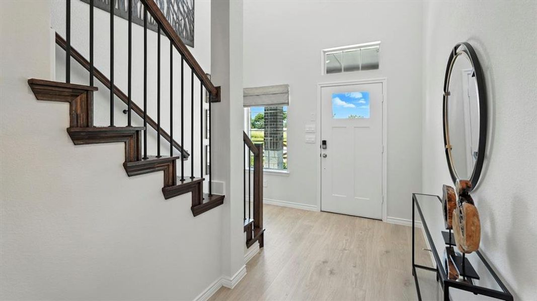 Foyer featuring light wood-type flooring and a high ceiling