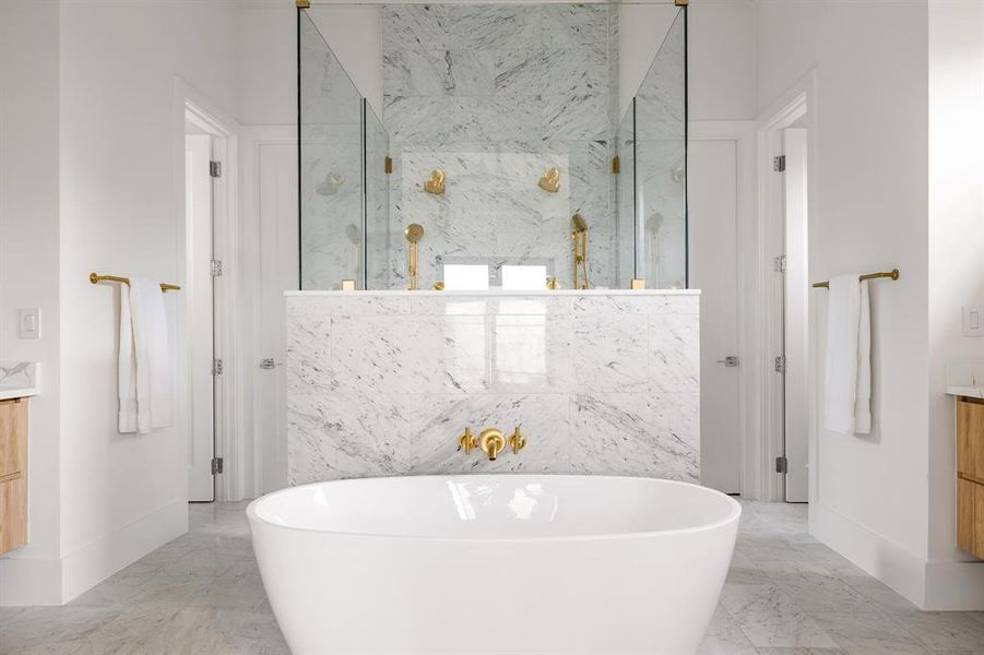 Full bath featuring marble finish floor, a freestanding tub, vanity, and a marble finish shower