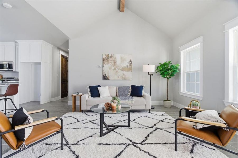 Living area featuring high vaulted ceiling, beam ceiling, and light wood-type flooring