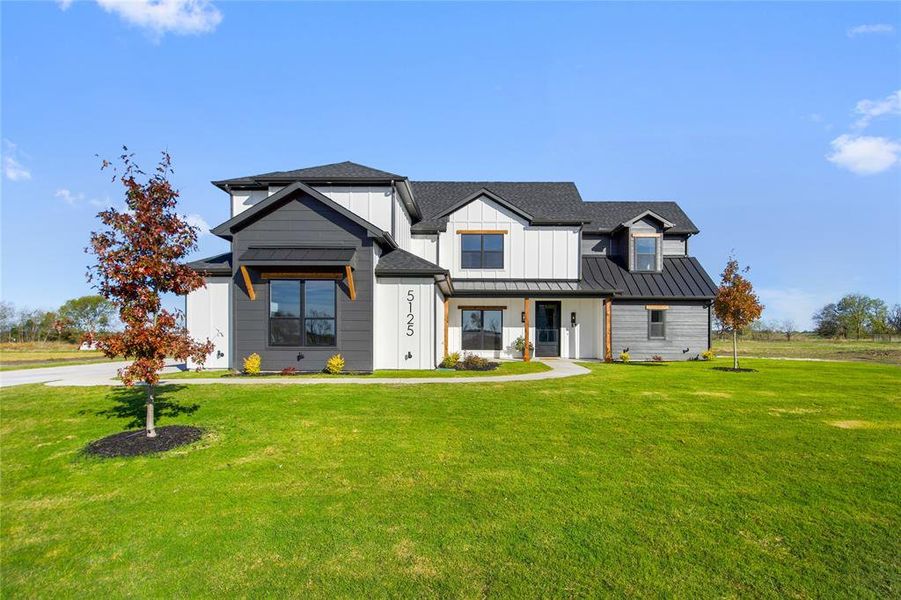 Modern farmhouse style home with a front yard