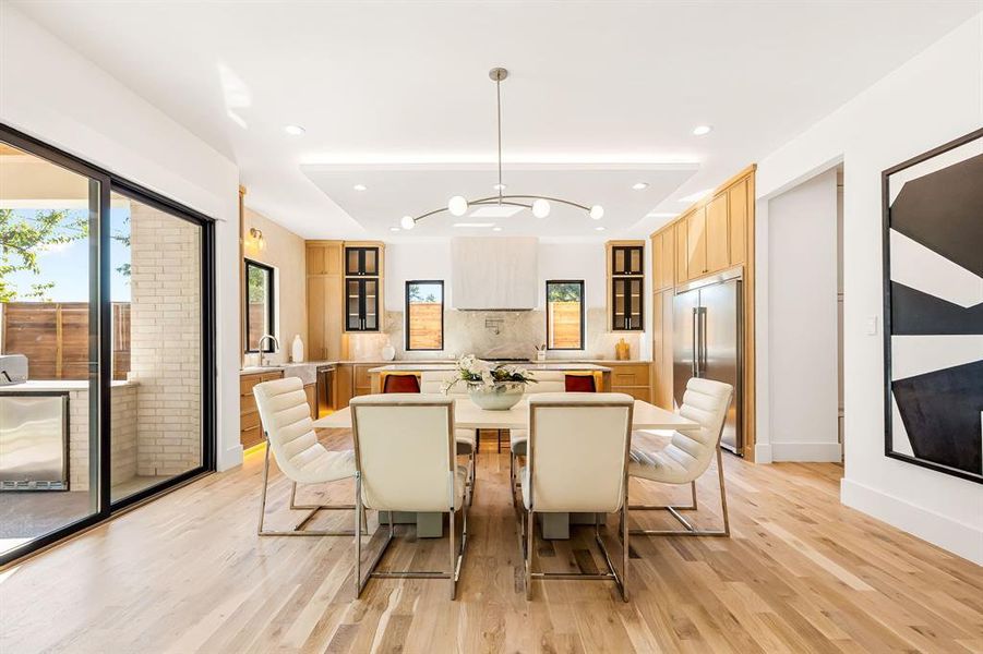 Dining area featuring light wood-style floors, recessed lighting, and a chandelier Dining area featuring light wood-style floors, recessed lighting, and a chandelier