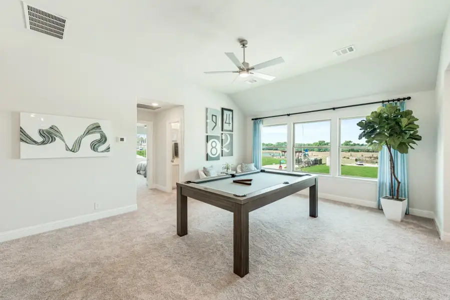 Game room with pool table, vaulted ceiling, ceiling fan, and large windows overlooking backyard