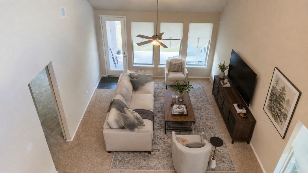 This room features a high ceiling with a central fan and three tall, vertical windows. A glass-paneled exterior door provides direct access to the outdoor area.**This room has been virtually staged.