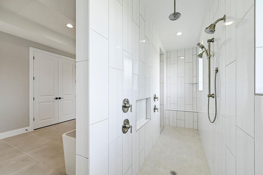 Indulge in a spa-like experience with this expansive walk-in shower, complete with dual showerheads.