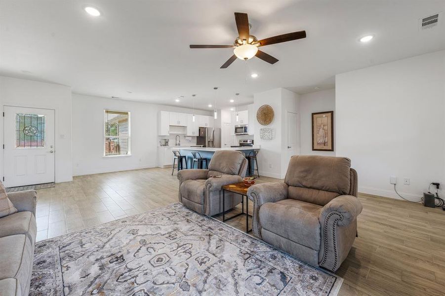 Living room featuring light wood-style floors, recessed lighting, and a ceiling fan