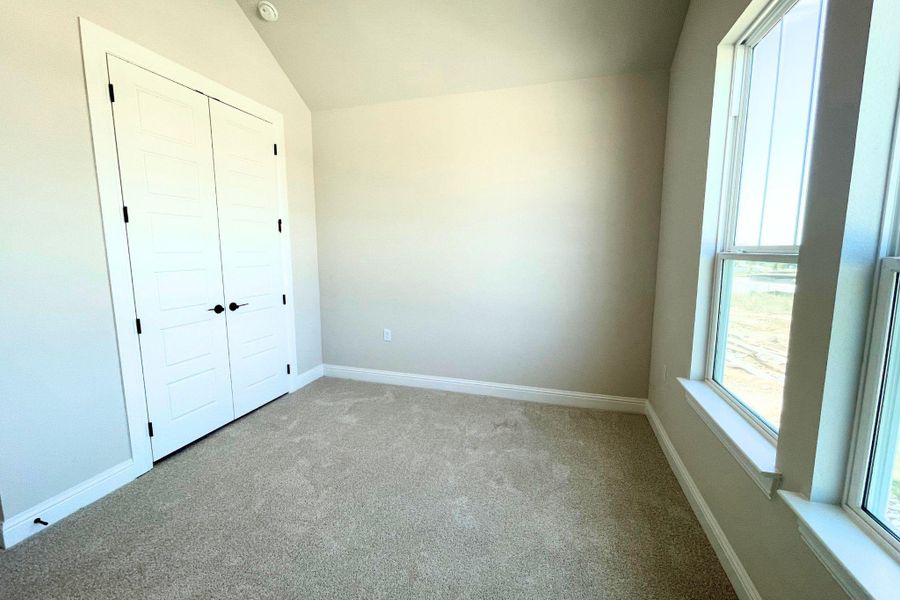 Vaulted ceilings and plush carpeting define this versatile secondary bedroom space. Vaulted ceilings and plush carpeting define this versatile secondary bedroom space.