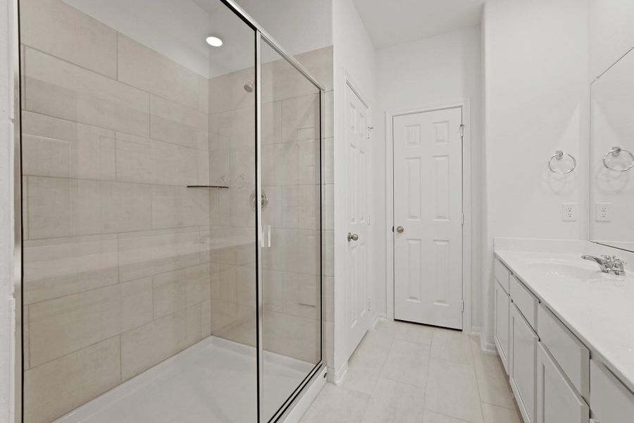This additional view of your primary bathroom features tile flooring, fresh paint, walk-in shower, and a large walk-in closet. This additional view of your primary bathroom features tile flooring, fresh paint, walk-in shower, and a large walk-in closet.