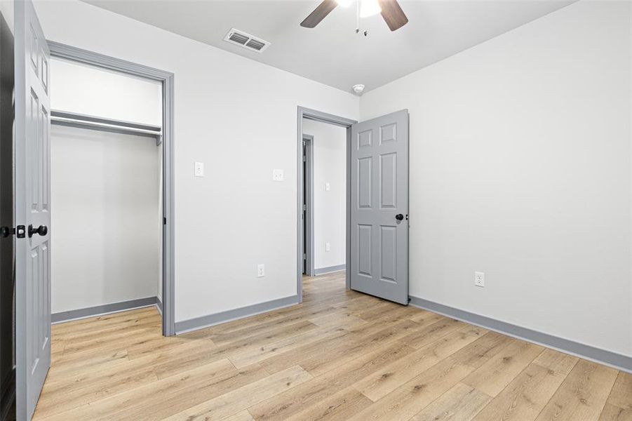 Unfurnished bedroom with light wood-style flooring, a ceiling fan, and a closet Unfurnished bedroom with light wood-style flooring, a ceiling fan, and a closet