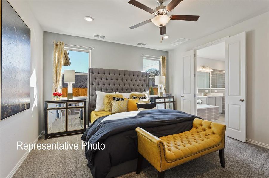 Bedroom featuring carpet flooring, ensuite bathroom, ceiling fan, and multiple windows