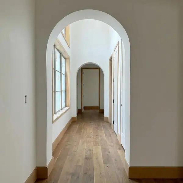 Arched opening to hall with natural light from windows. Arched opening to hall with natural light from windows.