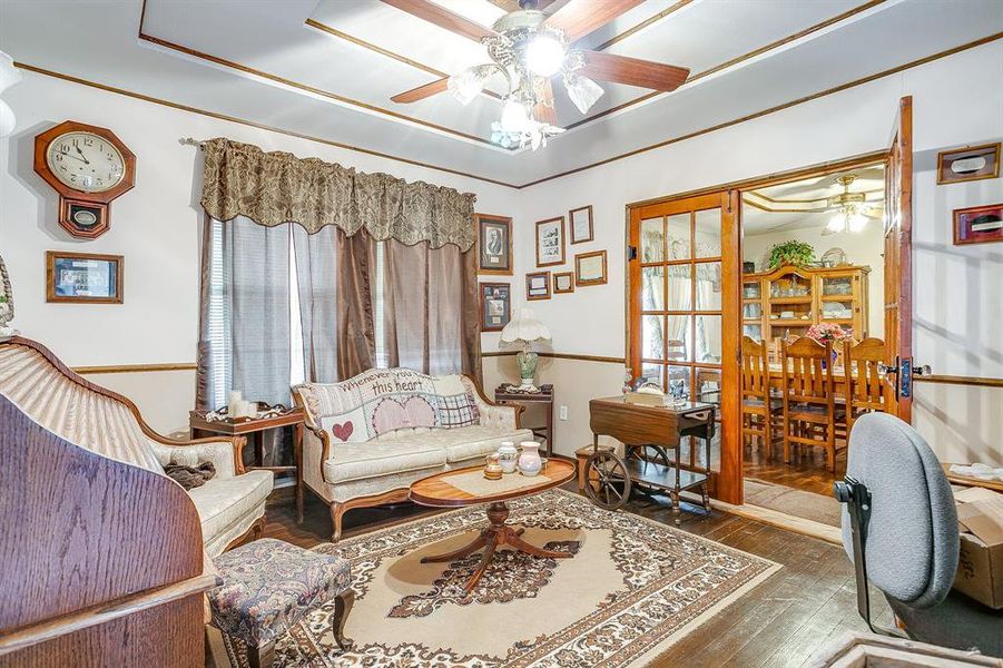 Sitting room featuring dark wood-type flooring and ceiling fan Sitting room featuring dark wood-type flooring and ceiling fan