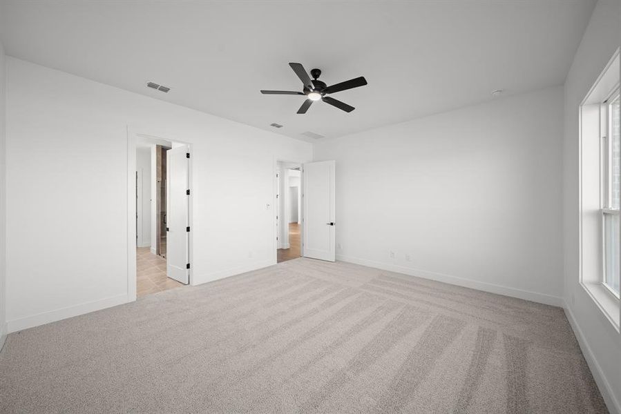 Unfurnished bedroom featuring light colored carpet and ceiling fan