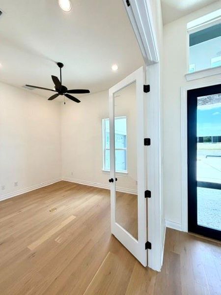 French doors open into a bright room with beautiful hardwood flooring. French doors open into a bright room with beautiful hardwood flooring.