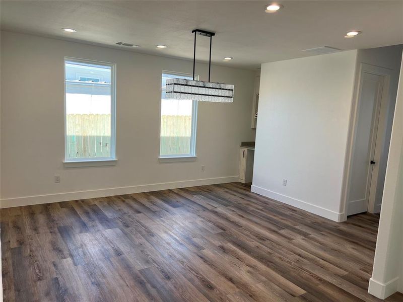 Unfurnished dining area featuring dark wood-style flooring and recessed lighting
