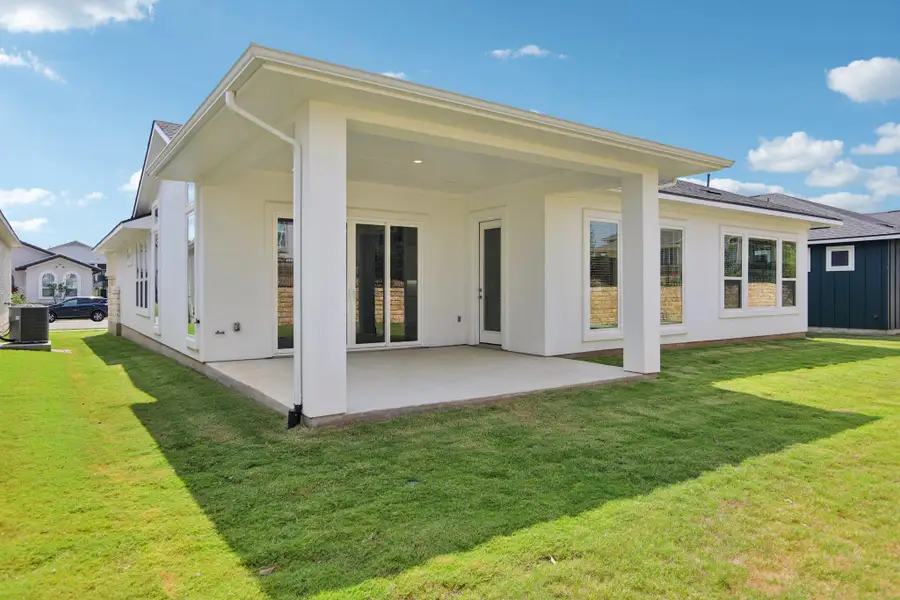 Back of property featuring a patio area, a yard, and stucco siding