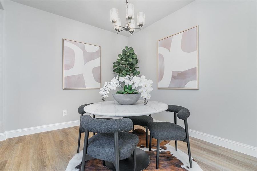 Dining area with light hardwood / wood-style flooring and a notable chandelier