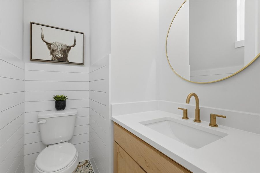 This stylish half bathroom features a sleek design with a modern vanity, gold fixtures, and a charming accent piece, creating a perfect blend of functionality and elegance. This stylish half bathroom features a sleek design with a modern vanity, gold fixtures, and a charming accent piece, creating a perfect blend of functionality and elegance.