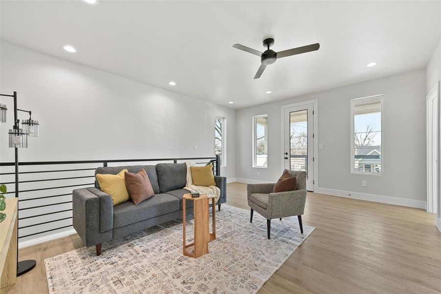 Living room with ceiling fan and light hardwood / wood-style flooring