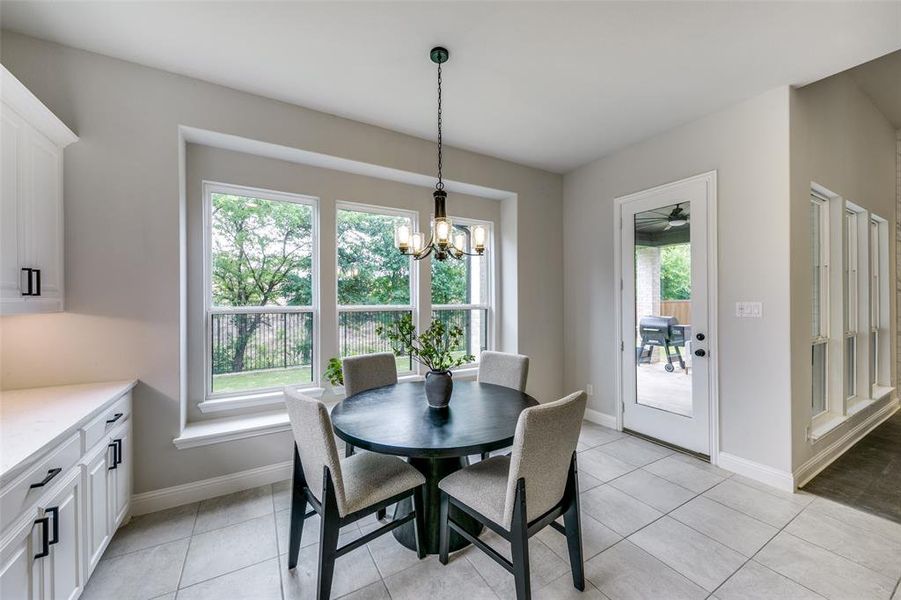 Dining space featuring a chandelier, plenty of natural light, and light tile floors