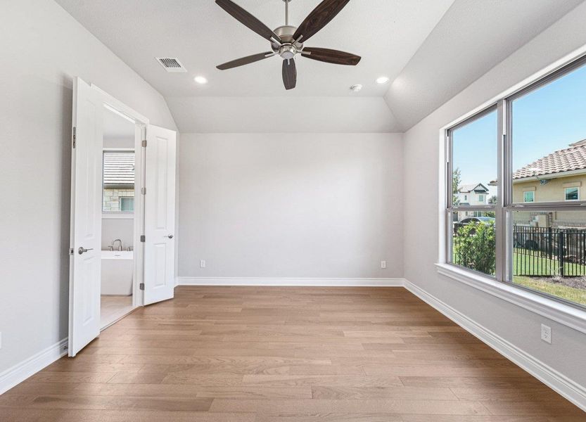 Empty room featuring lofted ceiling, ceiling fan, light wood finished floors, and recessed lighting