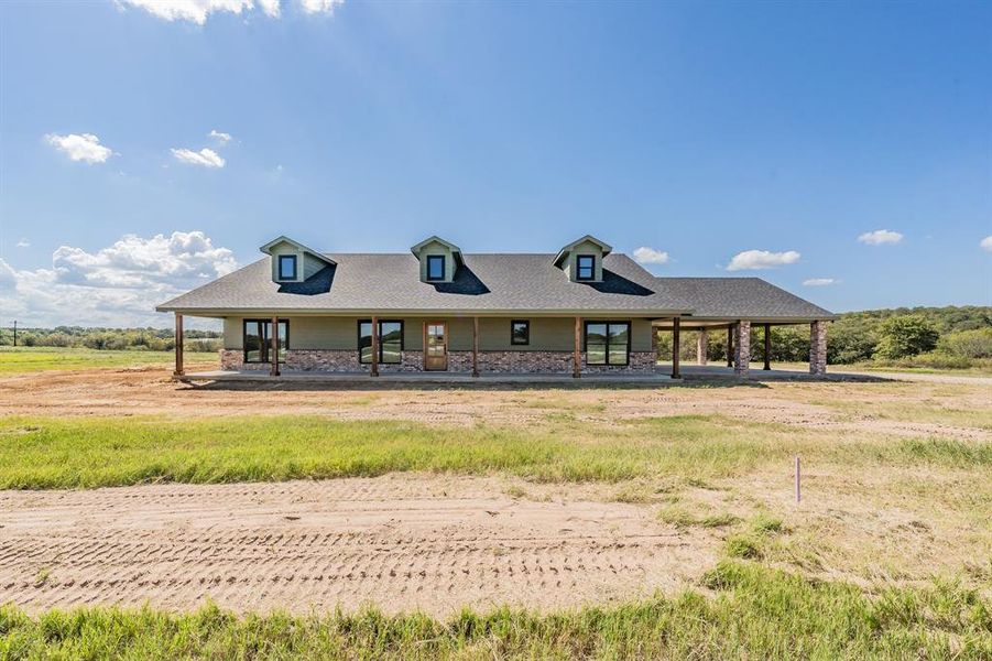 View of front of property featuring a porch, stone siding, and roof with shingles View of front of property featuring a porch, stone siding, and roof with shingles