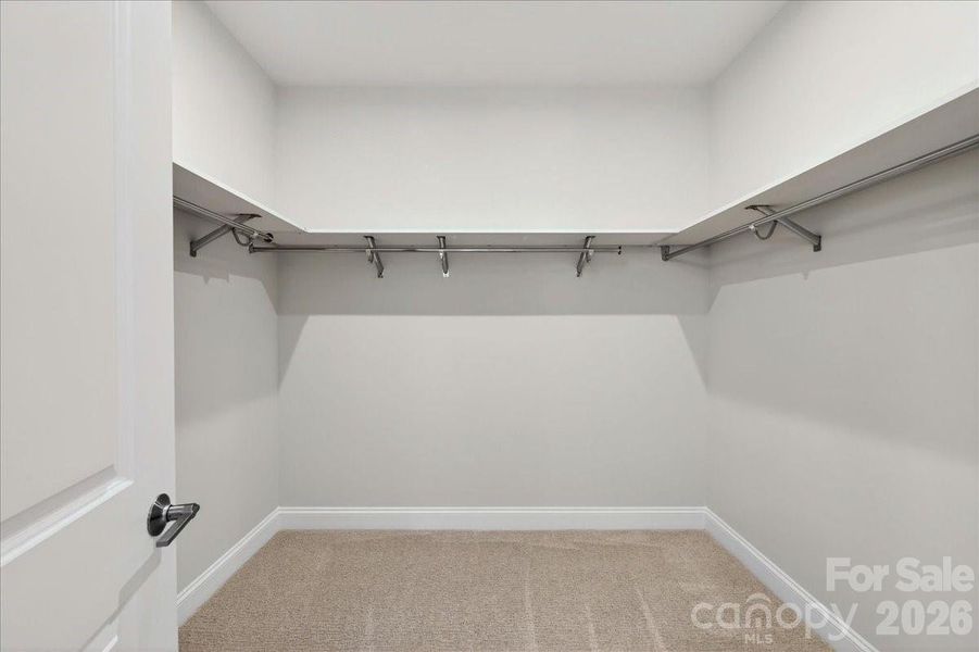 Large primary walk-in closet with upgraded shelves Large primary walk-in closet with upgraded shelves