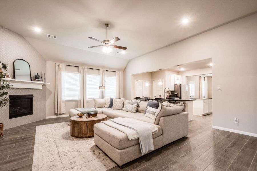 This inviting living room features an open floor plan. Spacious enough for a large sectional sofa. Modern fireplace, and large windows that let in plenty of natural light. The neutral color palette and stylish decor create a warm, welcoming atmosphere. Adjacent is a sleek kitchen with a breakfast bar, perfect for entertaining. This inviting living room features an open floor plan. Spacious enough for a large sectional sofa. Modern fireplace, and large windows that let in plenty of natural light. The neutral color palette and stylish decor create a warm, welcoming atmosphere. Adjacent is a sleek kitchen with a breakfast bar, perfect for entertaining.