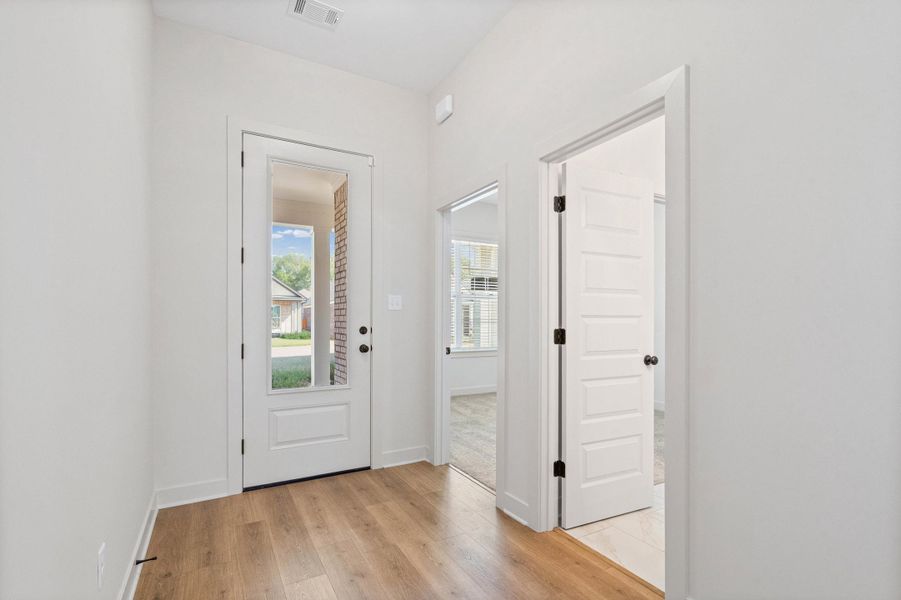 Doorway with hardwood / wood-style floors and baseboards
