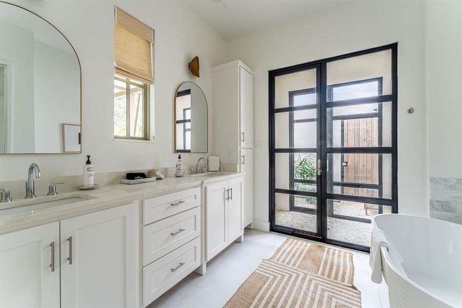 Bedroom with access to exterior, finished concrete flooring, ceiling fan, beamed ceiling, and french doors Bedroom with access to exterior, finished concrete flooring, ceiling fan, beamed ceiling, and french doors