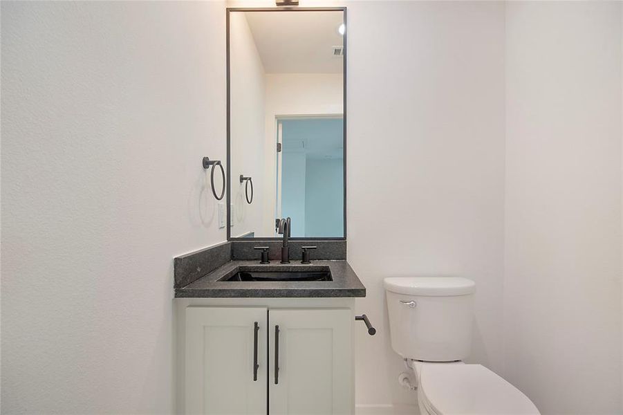 Half bathroom with vanity and toilet