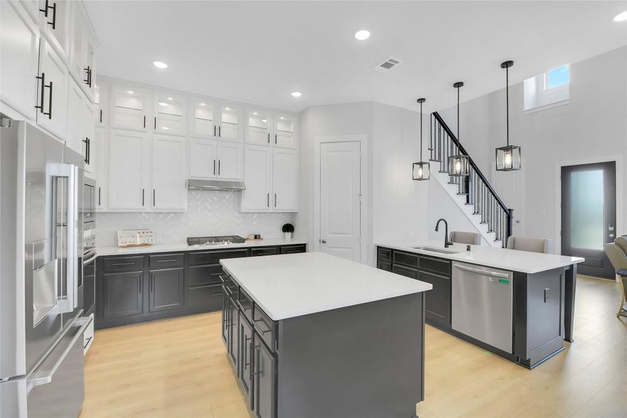 Huge central island, designer cabinet look with dark lowers and bright uppers. Large Walk-in Pantry