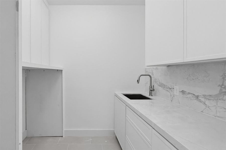 Convenient and functional, the well-appointed utility room features built-in storage and a utility sink designed to simplify everyday tasks.