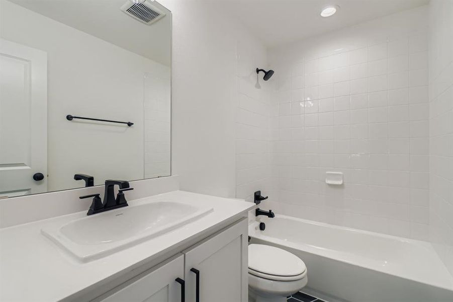 Bathroom with shower / washtub combination, vanity, and recessed lighting