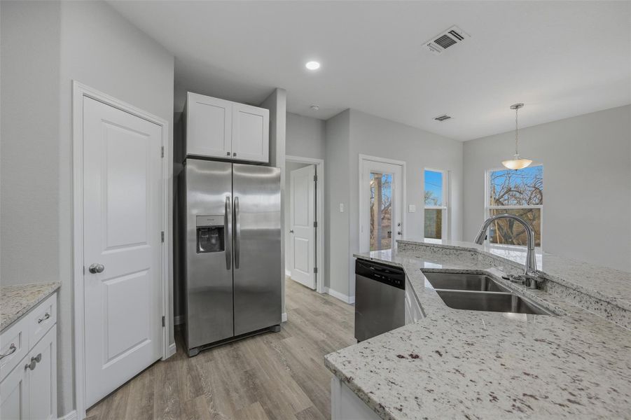 A well-appointed kitchen showcases granite counters, stainless steel appliances, and ample cabinet storage.