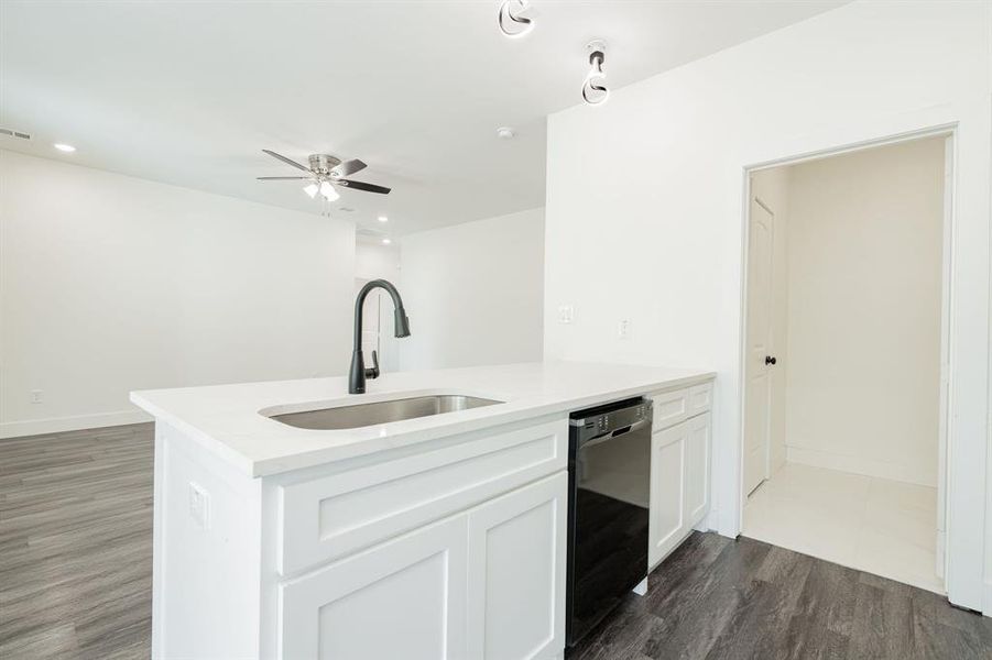 Kitchen featuring sink, ceiling fan, dark hardwood / wood-style floors, black dishwasher, and white cabinets